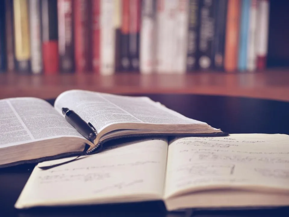 An open notebook and pen on a library table